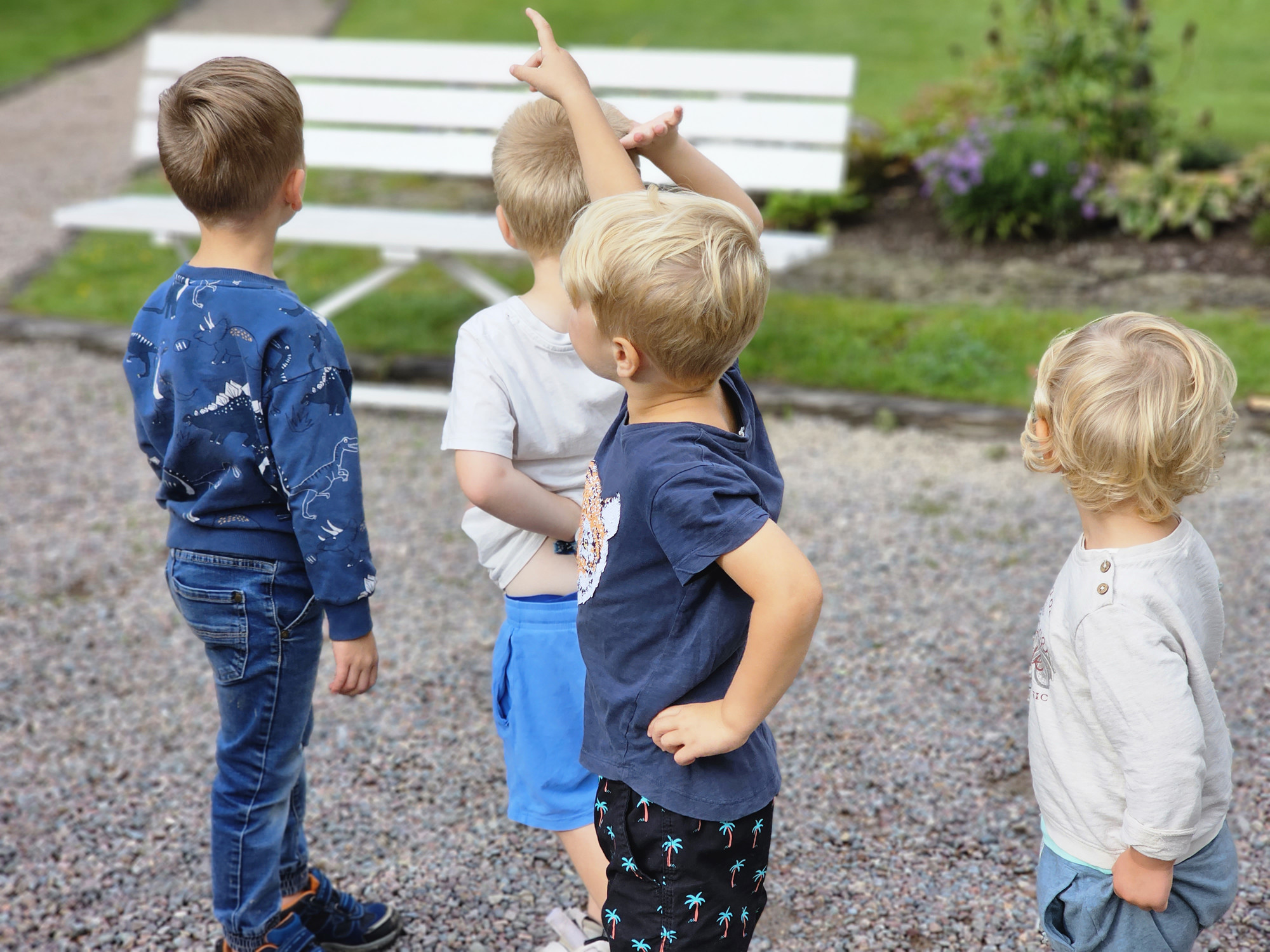 Bilden visar barn som tittar bort och pekar på något utanför bilden.